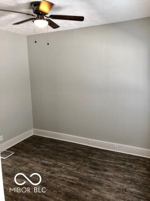 unfurnished room with dark wood-style floors, a textured ceiling, baseboards, and a ceiling fan