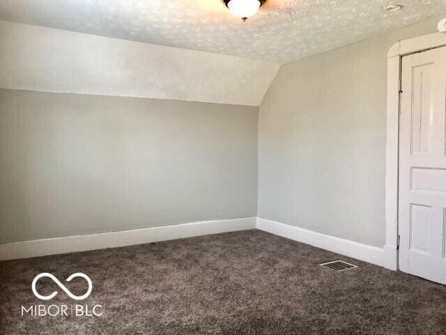 bonus room featuring visible vents, baseboards, vaulted ceiling, a textured ceiling, and carpet flooring