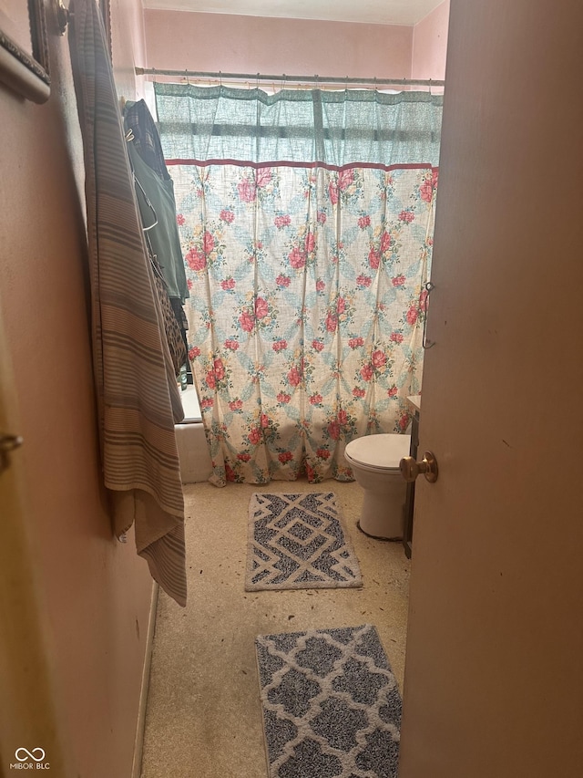 full bath featuring a shower with curtain, baseboards, and toilet