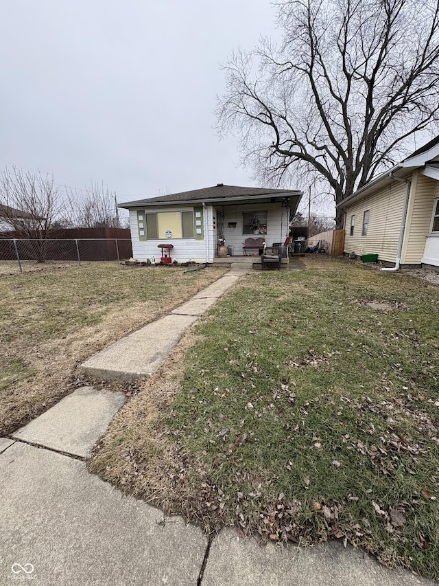 bungalow with a front yard and fence