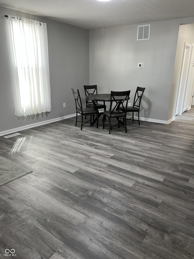 dining area featuring visible vents, baseboards, and dark wood-style floors