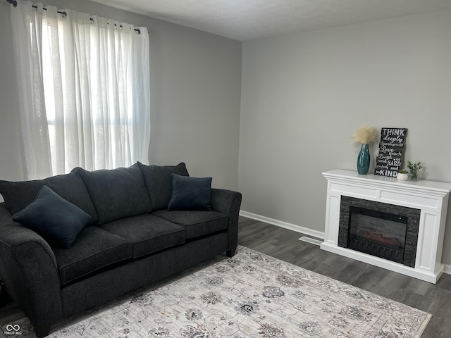 living room with a fireplace, wood finished floors, and baseboards