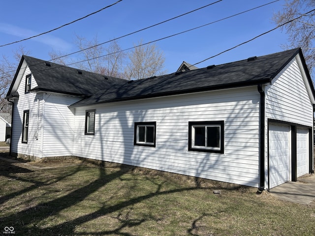 view of side of property with a yard and roof with shingles