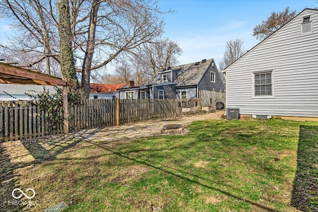 view of yard featuring central air condition unit, fence, and a fire pit