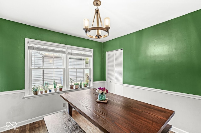 dining room featuring a chandelier, wainscoting, and wood finished floors