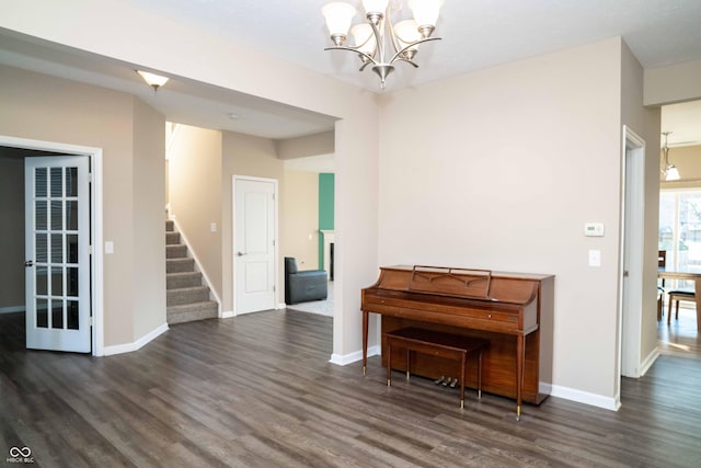 interior space with an inviting chandelier, stairway, wood finished floors, and baseboards