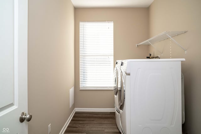 washroom featuring laundry area, baseboards, dark wood-type flooring, and washer and clothes dryer