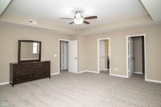 bedroom featuring a tray ceiling, visible vents, baseboards, and carpet