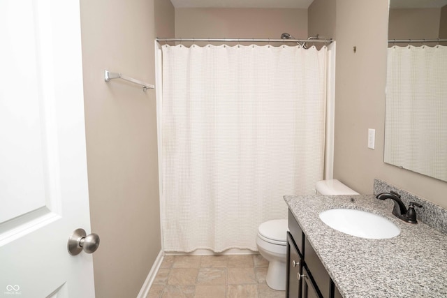 bathroom with a shower with curtain, toilet, stone finish flooring, baseboards, and vanity