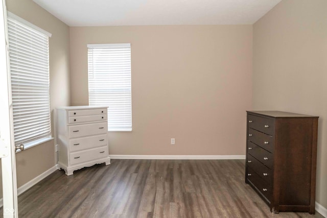 unfurnished bedroom featuring baseboards and dark wood-style floors