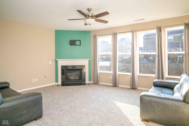 living room featuring baseboards, a fireplace with flush hearth, and carpet