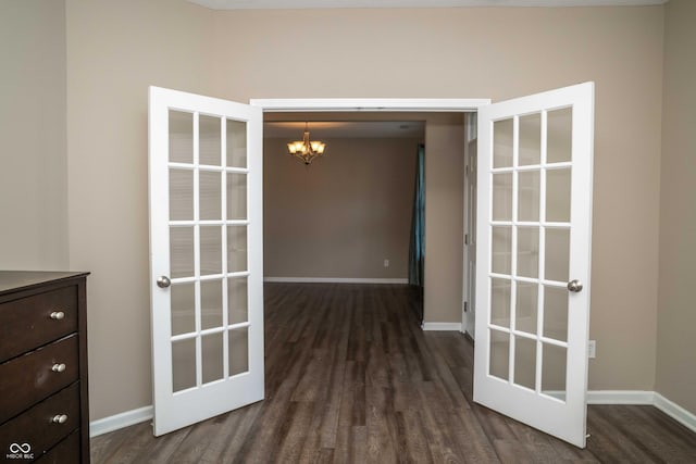 interior space with a notable chandelier, baseboards, and dark wood-style flooring