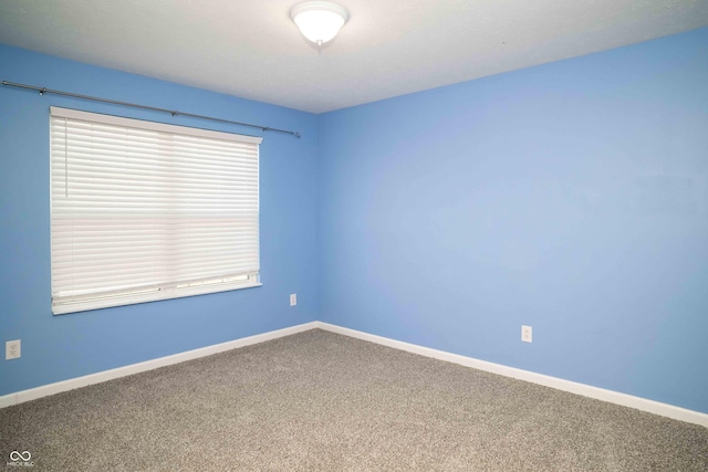 carpeted empty room with baseboards