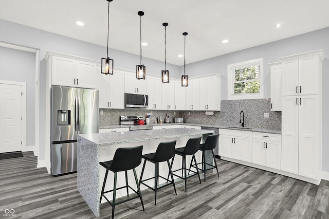 kitchen with backsplash, a kitchen island, appliances with stainless steel finishes, and a sink