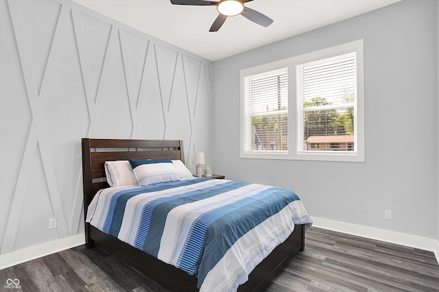 bedroom featuring baseboards, wood finished floors, and a ceiling fan