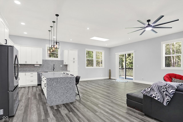 living room featuring recessed lighting, wood finished floors, baseboards, and ceiling fan