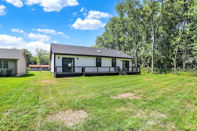 back of property with a yard and a deck