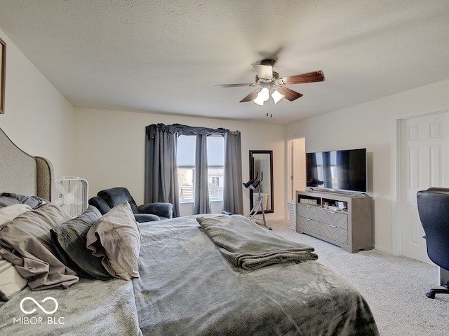 bedroom with light carpet, baseboards, a textured ceiling, and a ceiling fan