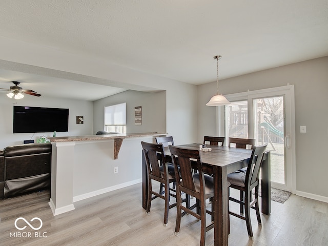 dining space featuring light wood-type flooring, baseboards, and ceiling fan