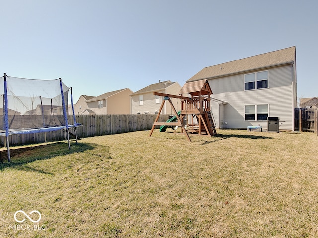 rear view of property with a playground, a trampoline, a fenced backyard, and a yard