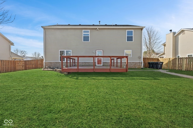 back of house with a wooden deck, a lawn, and a fenced backyard