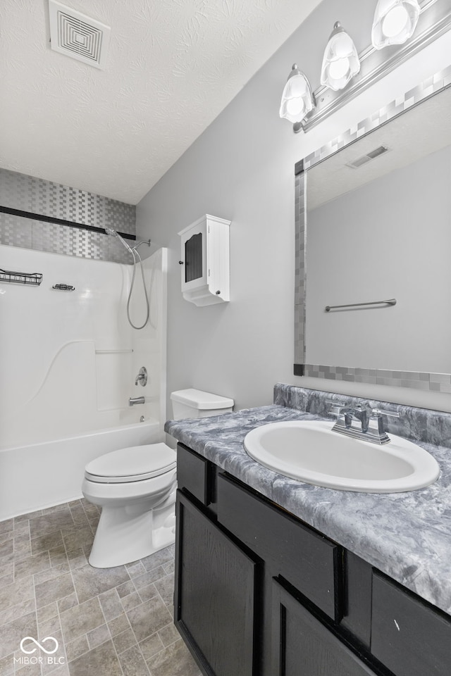 bathroom featuring visible vents, toilet, a textured ceiling, bathtub / shower combination, and vanity