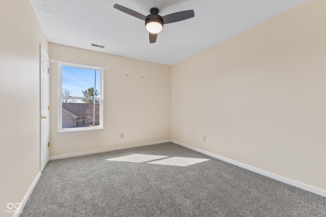 carpeted spare room featuring visible vents, a textured ceiling, baseboards, and ceiling fan