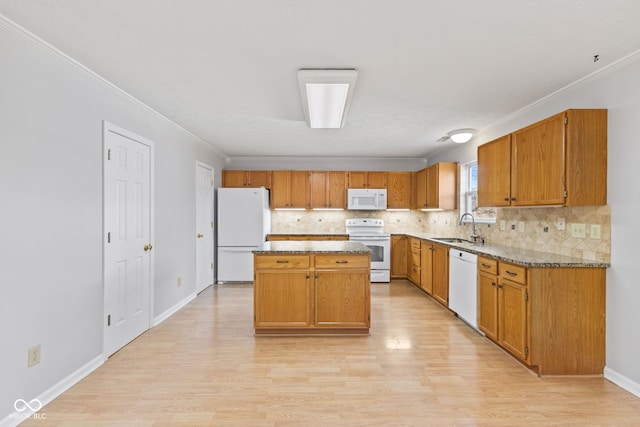 kitchen featuring a sink, white appliances, light wood-style floors, and ornamental molding