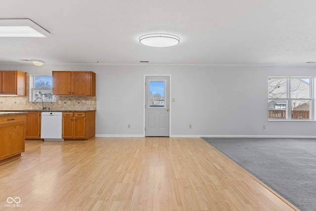 kitchen with open floor plan, white dishwasher, backsplash, and a sink