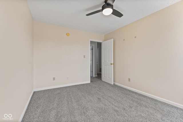 empty room with carpet flooring, baseboards, and ceiling fan