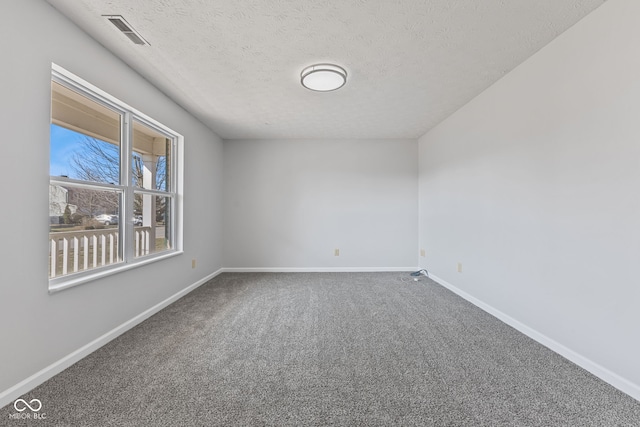 carpeted empty room with visible vents, baseboards, and a textured ceiling