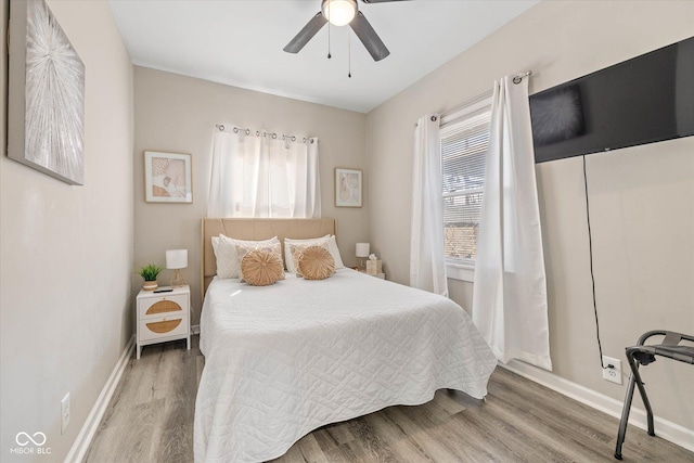 bedroom featuring a ceiling fan, baseboards, and wood finished floors