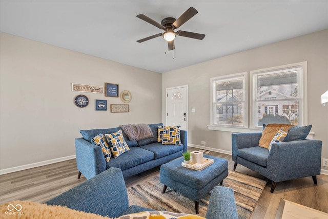 living room featuring ceiling fan, baseboards, and wood finished floors