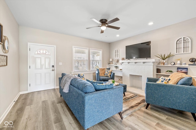 living area with wood finished floors, recessed lighting, a fireplace, baseboards, and ceiling fan