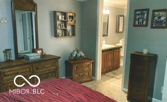 bedroom with light colored carpet and ensuite bath