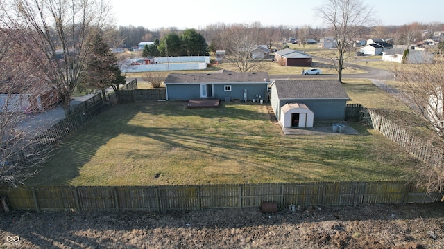 view of yard with a storage unit, an outdoor structure, and a fenced backyard