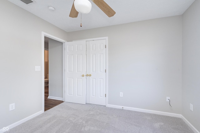 unfurnished bedroom featuring a closet, baseboards, ceiling fan, and carpet flooring