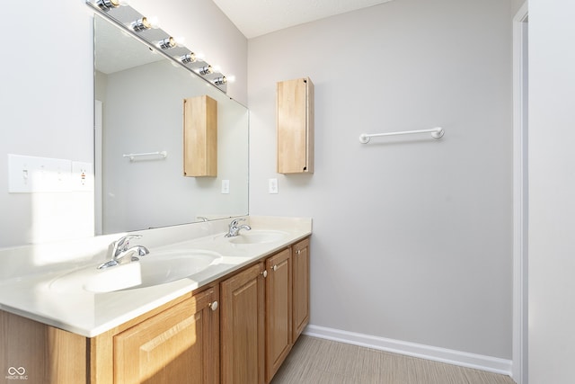 full bathroom with a sink, baseboards, and double vanity