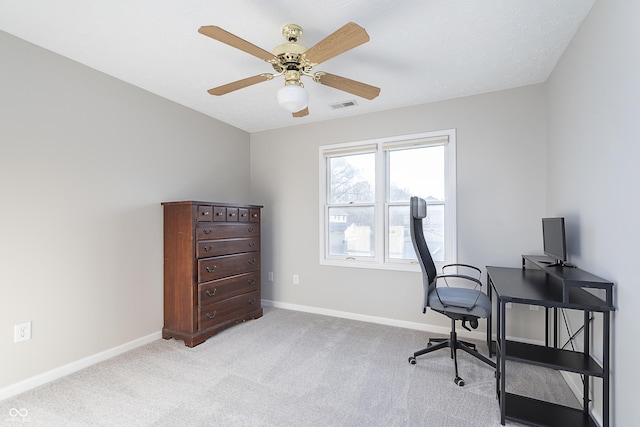 office featuring ceiling fan, light colored carpet, visible vents, and baseboards