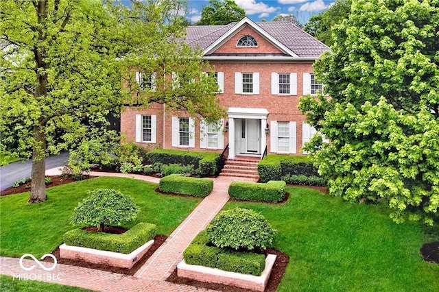 view of front of house with brick siding and a front lawn