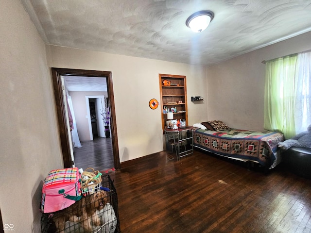 bedroom with baseboards and hardwood / wood-style floors