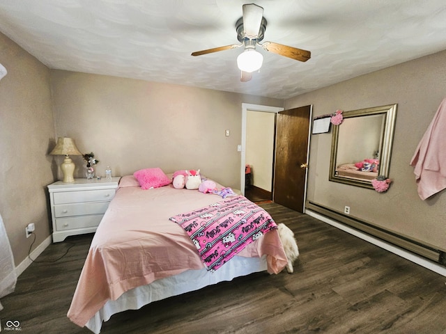 bedroom featuring a baseboard heating unit, wood finished floors, baseboards, and a ceiling fan