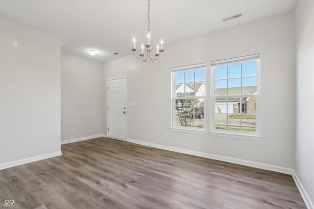 interior space with an inviting chandelier, visible vents, wood finished floors, and baseboards