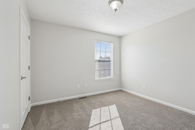 unfurnished room featuring visible vents, baseboards, carpet, and a textured ceiling