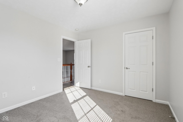 unfurnished bedroom with baseboards and carpet