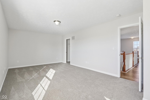 carpeted empty room featuring visible vents and baseboards