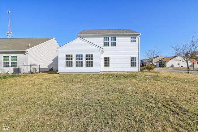 back of property with a yard, central air condition unit, and fence