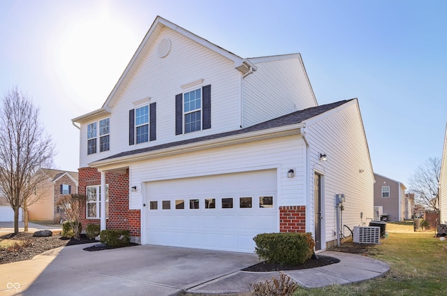 traditional-style home featuring a garage, brick siding, and driveway