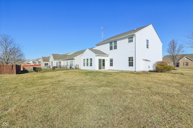 rear view of house featuring a patio area, a yard, and fence