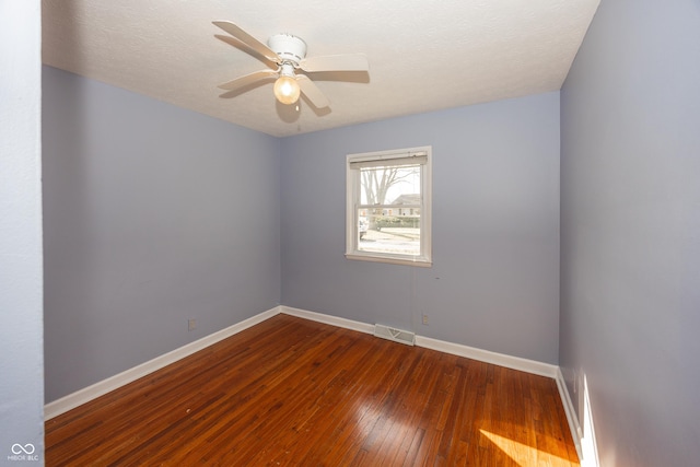 empty room featuring hardwood / wood-style floors, baseboards, visible vents, ceiling fan, and a textured ceiling